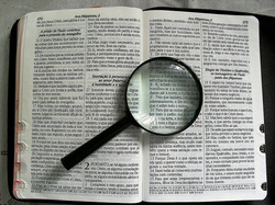 This is a Bible... with a magnifying glass. I think it's supposed to symbolise looking at it closely...